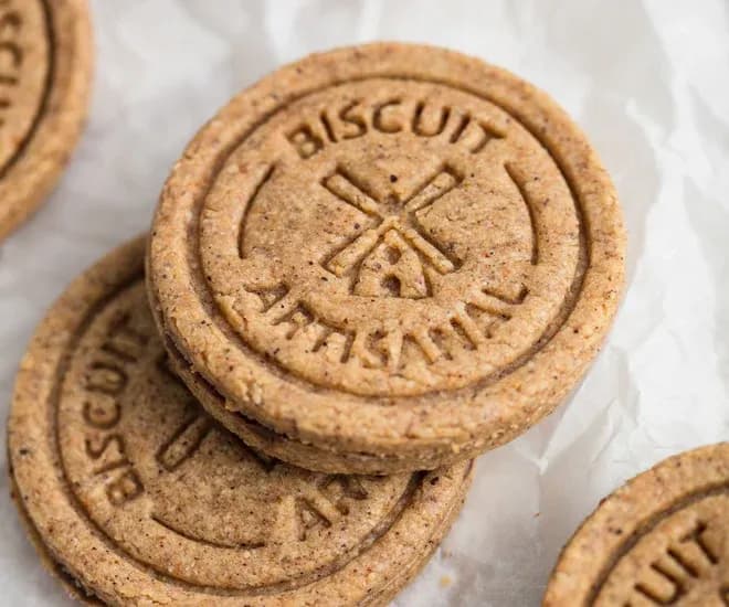 sablés ronds estampillés d'un moulin empilés sur papier