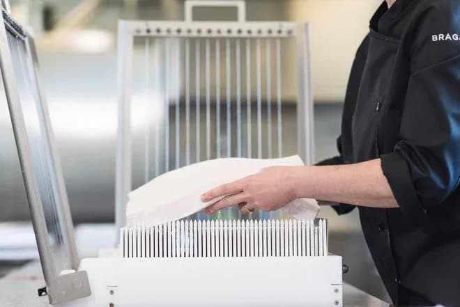 Préparation de confiserie avec un outil spécifique et un professionnel en cuisine.