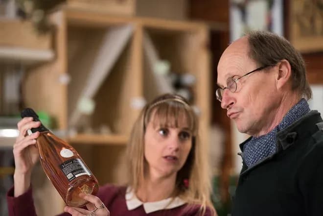 discussion entre deux personnes sur une bouteille de vin dans un magasin spécialisé