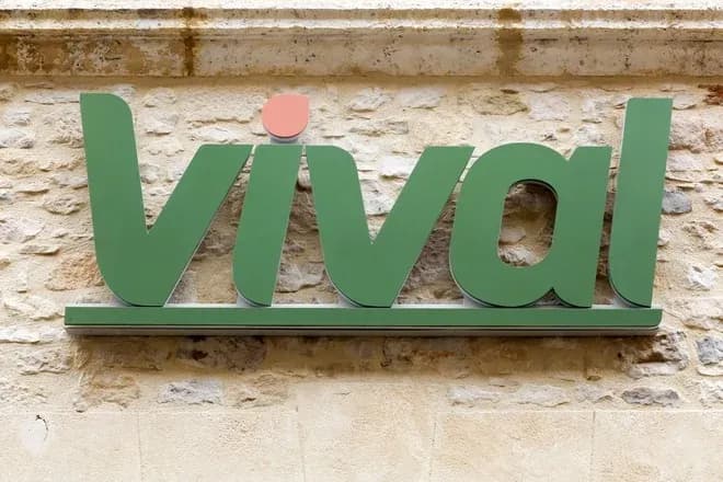 enseigne vival verte fixée sur une façade en pierre