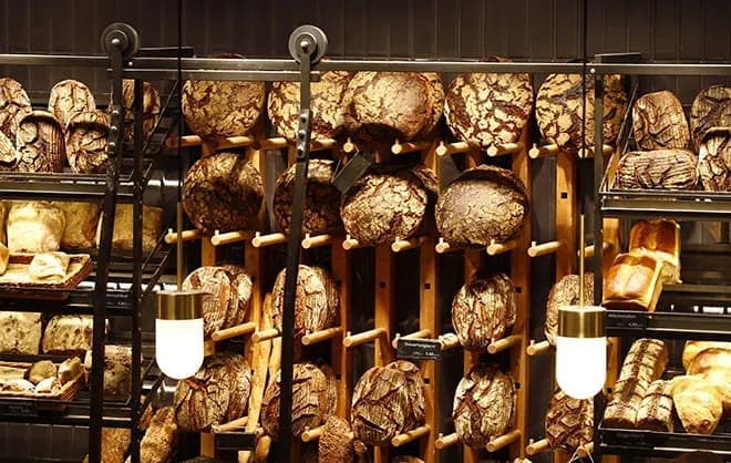 pains ronds rustiques sur présentoir mural en bois sous lumière chaude