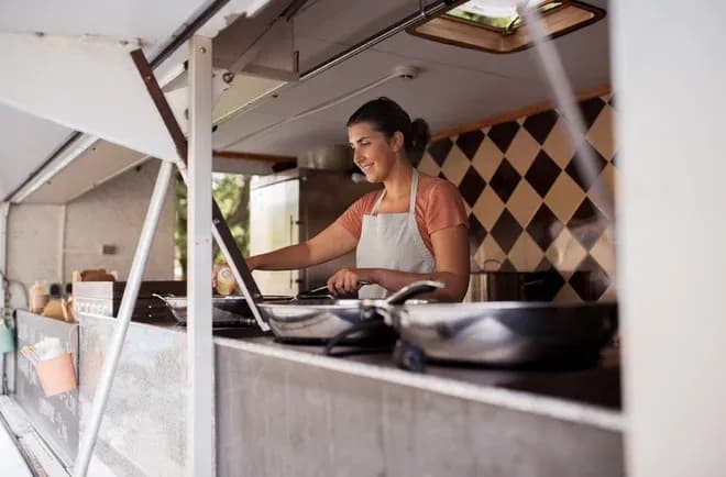 femme préparant des plats dans un food truck avec des ustensiles de cuisine