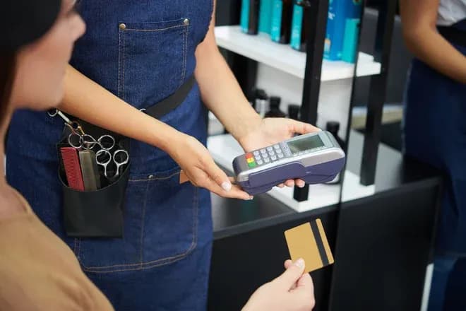 transaction de paiement dans un salon de coiffure avec carte bancaire et terminal de paiement