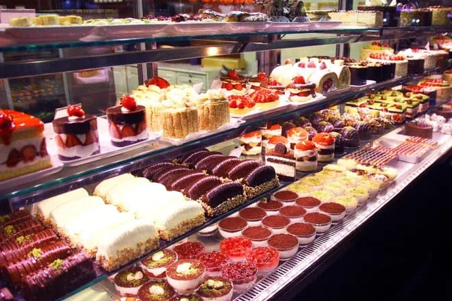 vitrine réfrigérée garnie de pâtisseries variées, éclairs, tartes et entremets
