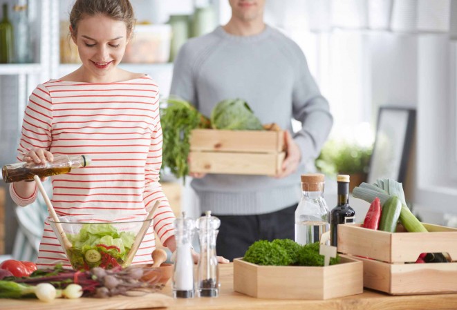 Couple entrain de préparer une salade verte bio