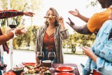 Femme tenant une brochette de viande au dessus de sa bouche.