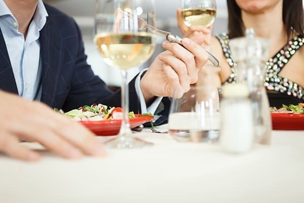 Deux clients entrain de manger au restaurant, et de boire du vin blanc