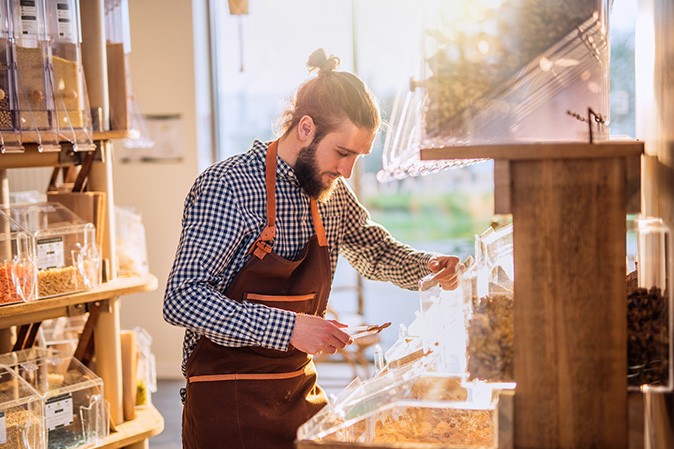 homme dans un magasin qui range des aliments dans un rayon