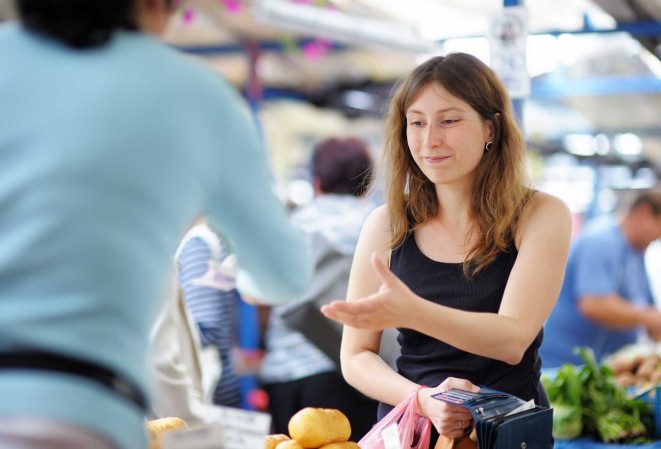 Commerçante de marché entrain d'encaisser une cliente