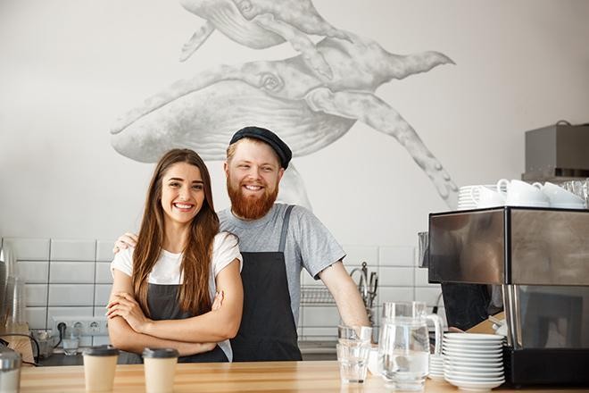 Entrepreneur et sa conjointe devant un comptoir de café restaurant