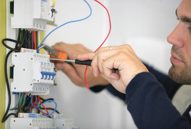 Électricien entrain d'installer un tableau électrique