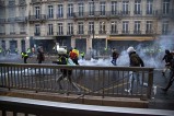 Gilets jaunes entrain de manifester dans une rue commerçante