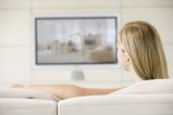 Femme qui regarde la télévision depuis son canapé