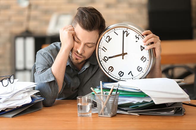 Homme fatigué tenant une horloge