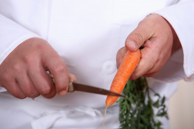 cuisinier entrain de couper une carotte