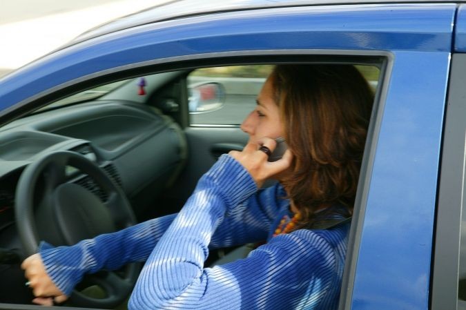 Conductrice entrain de téléphoner au volant de sa voiture bleue