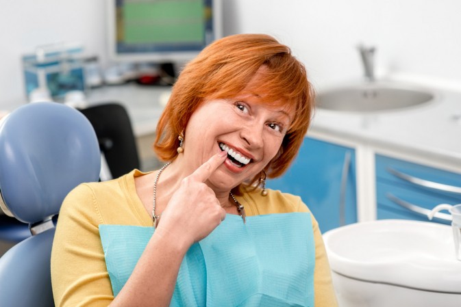 Femme qui vient de se faire poser un implant dentaire