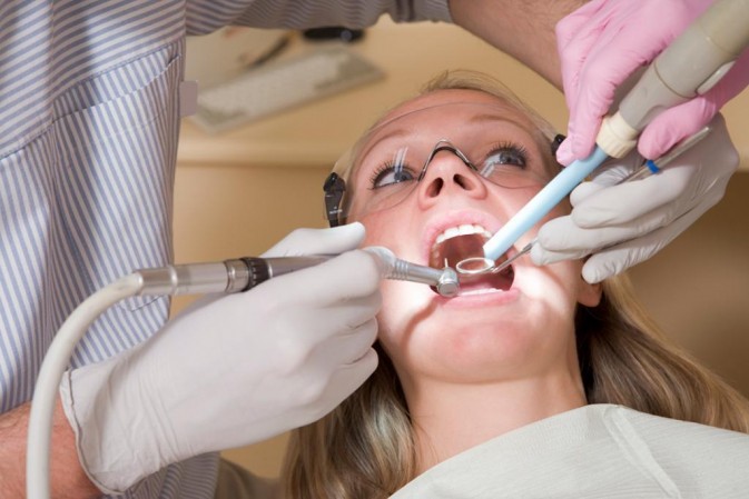 Dentiste entrain d'administrer des soins dentaires à une patiente 