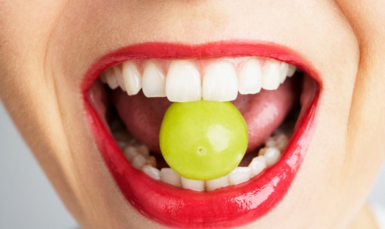 Bouche d'une femme entrain de manger un raisin