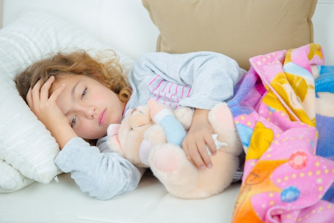 Jeune fille malade allongée sur le canapé avec son ours en peluche