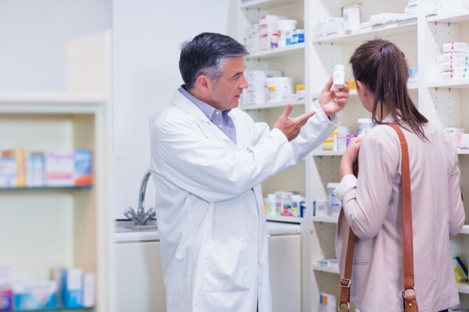 Pharmacien qui conseille une cliente sur un médicament 