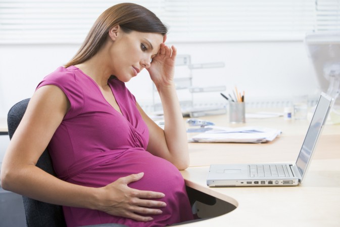 Femme enceinte entrain d'avoir des nausées au bureau