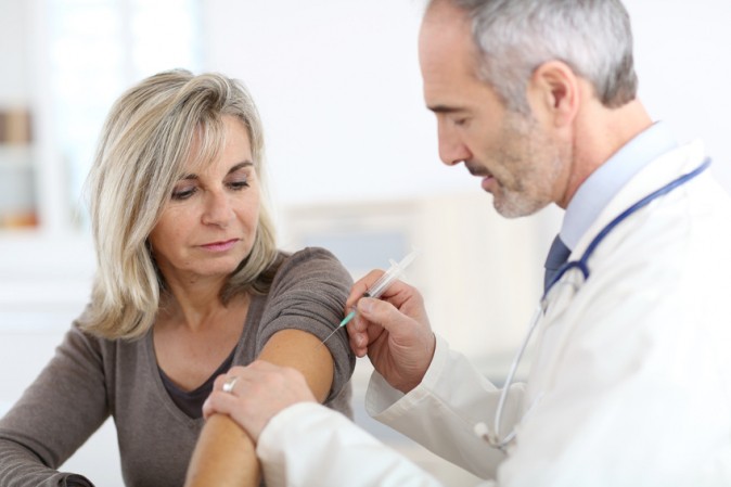 Médecin en train d'administrer un vaccin à une patiente pour prévenir de la grippe saisonnière
