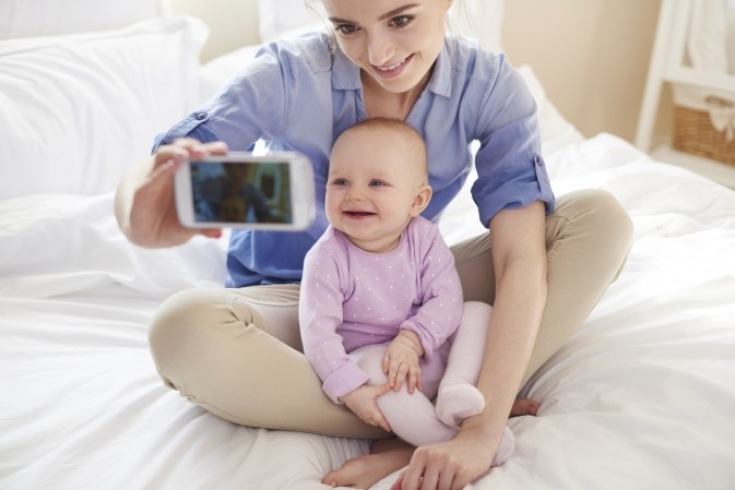 Maman entrain de prendre un selfie avec son bébé