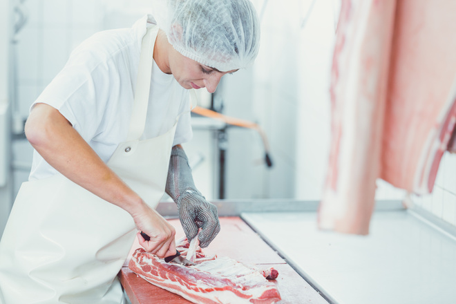 Bouchère découpe un morceau de viande