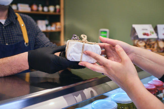 Fromager sert un fromage emballé à une cliente