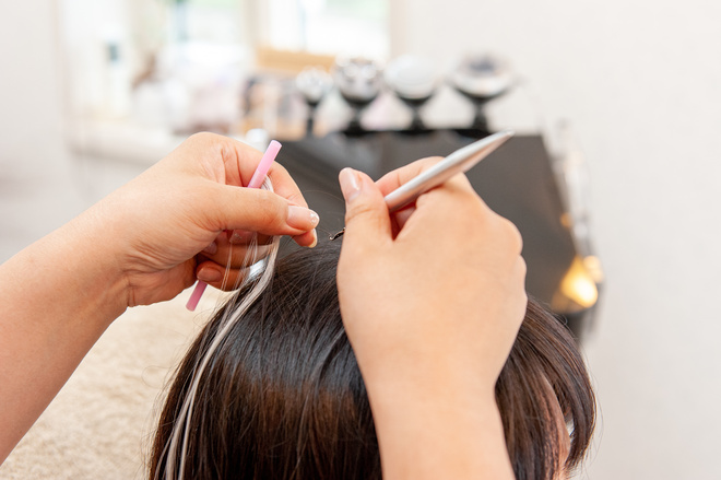 Coiffeuse met des extensions à une cliente