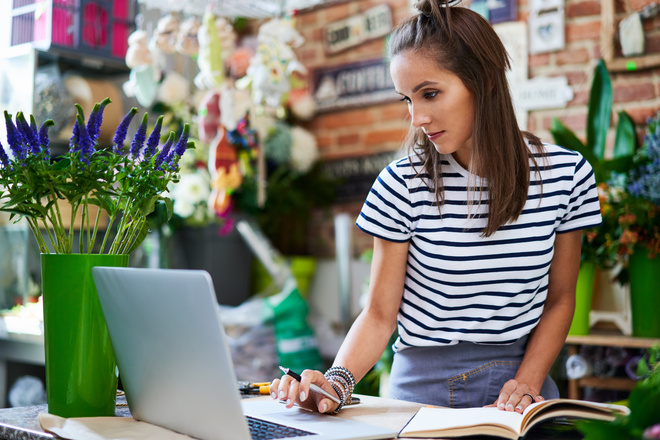 Fleuriste fait les comptes sur son ordinateur