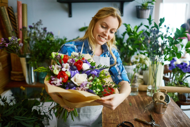 Fleuriste qui a réalisé un bouquet de fleurs multicolor