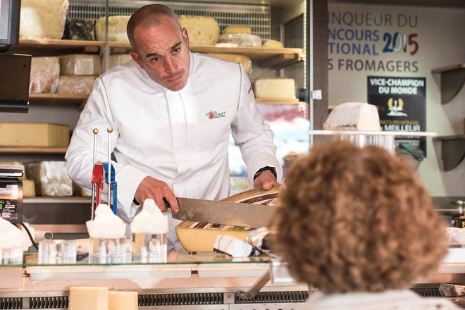 Découpe d'un morceau de fromage pour une cliente