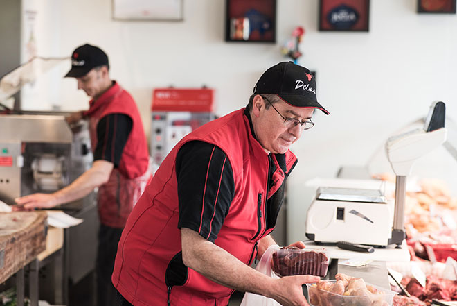 Boucher entrain de mettre en rayon les pièces du jour