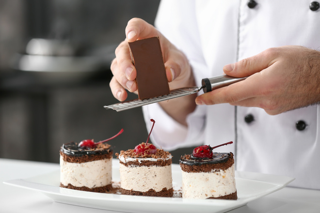 Râpage de chocolat sur petits gâteaux forêt noire