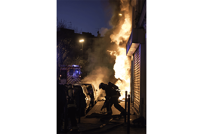Pompier devant un bâtiment en feu