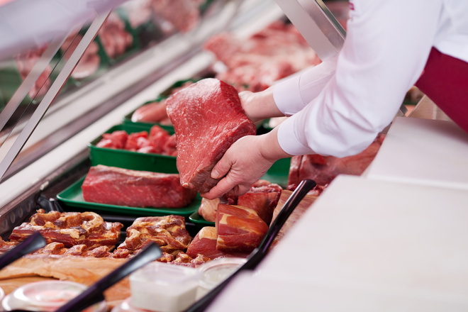 Mise en rayon de pièces de viande rouge dans une boucherie