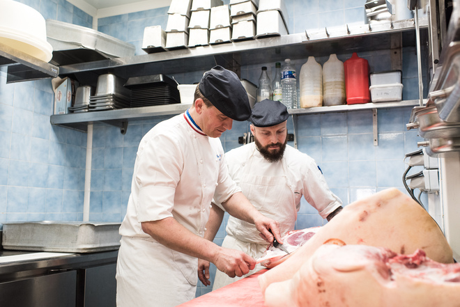 MOF charcutier entrain de découper une pièce de viande