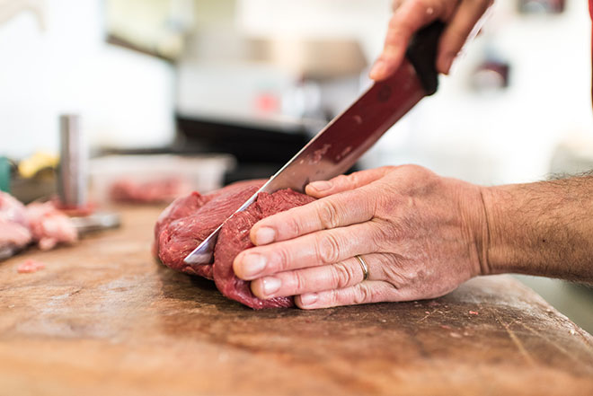 Découpe d'une pièce de viande en boucherie