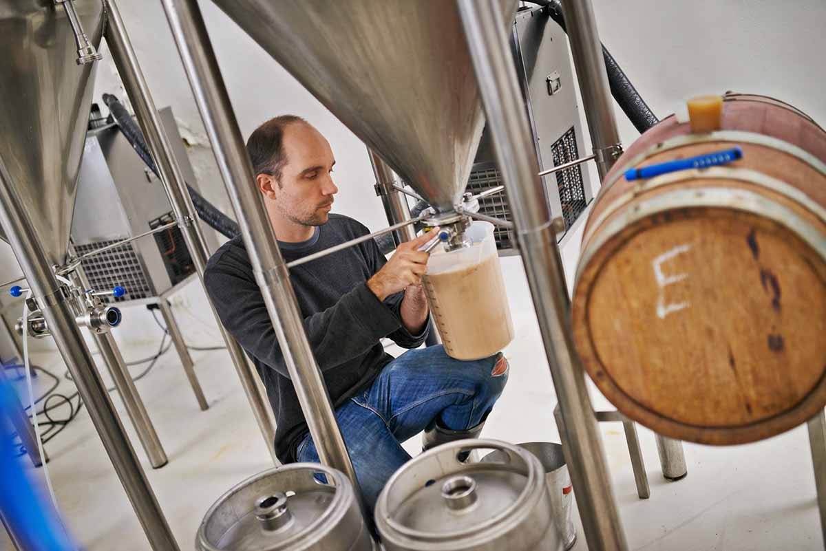 Brasseur extrait bière de sa cuve
