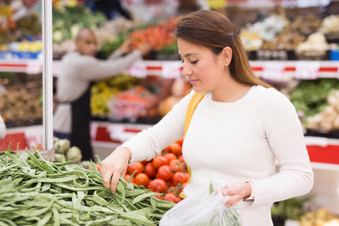 Cliente achète des haricots plats dans une épicerie