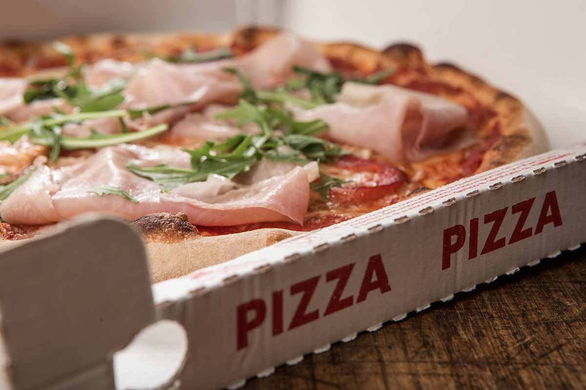 Gros plan sur une pizza dans une boîte à emporter