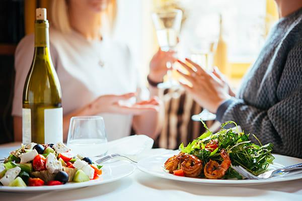 Table de restaurant avec des plats et du vin sur une nappe blanche