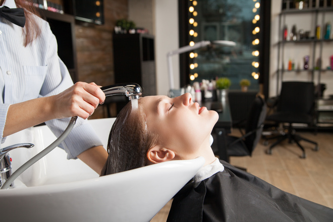 Coiffeuse entrain de laver les cheveux d'une cliente