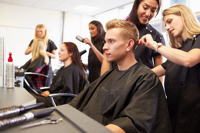 Élèves en MC coiffure entrain de couper les cheveux d'un client