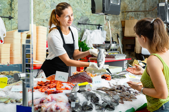 Poissonnière vend du poisson à une cliente
