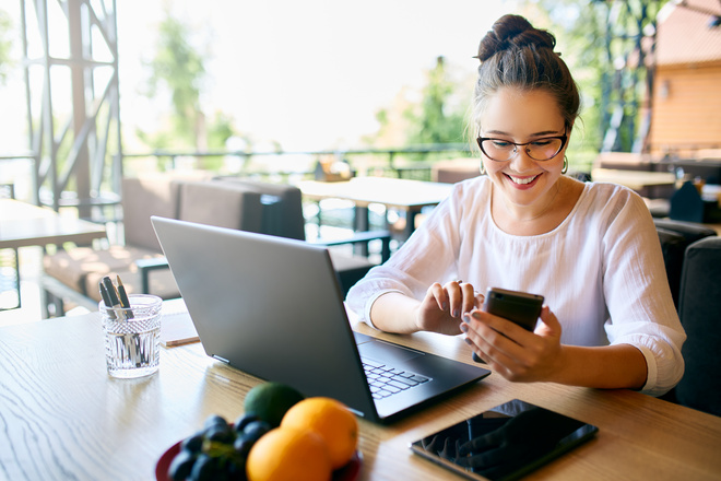 Restauratrice sur son ordinateur et son téléphone