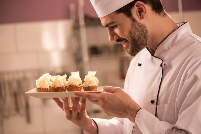 Pâtissier dresse des tartelettes sur une assiette