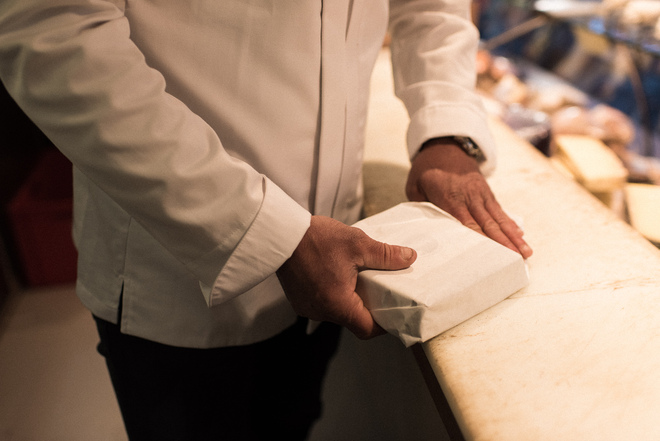 Emballage d'un fromage pour un client dans une fromagerie